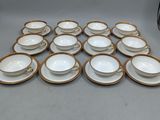une pile de tasses et soucoupes en porcelaine blanche et dorée