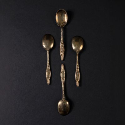 three spoons and a spoon rest on a black surface