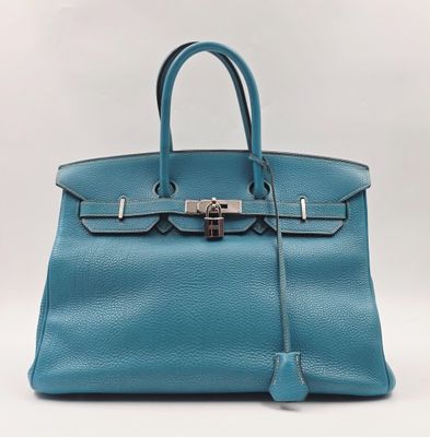 un sac à main en cuir bleu muni d'un cadenas sur la poignée
