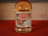 a bottle of peach wine sitting on a red table