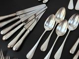 a lot of silver spoons and forks on the table