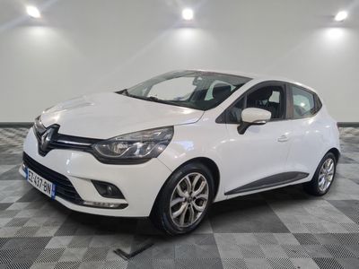 une voiture blanche est garée dans une pièce au sol à carreaux