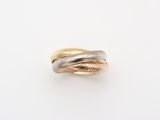 gros plan d'une bague en or et en argent sur une surface blanche