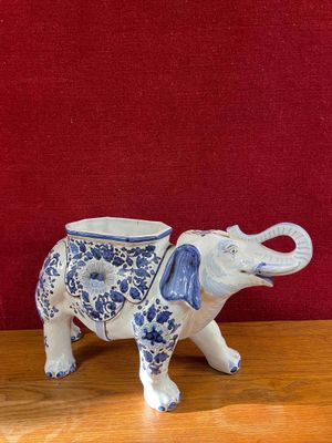 a blue and white elephant figurine sitting on a wooden table