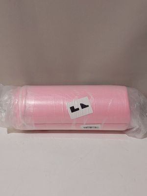 un gros plan sur une bobine de fil rose posée sur une surface blanche