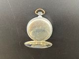 a close up of a pocket watch on a black surface