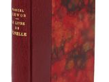 un vieux livre à la couverture rouge posé sur une surface blanche