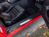 a red car with black leather seats and a steering wheel