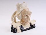a figurine of a woman with a hat on her head