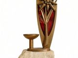 a statue of a vase and a candle on a stand