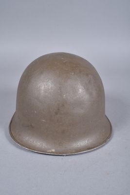 un vieux casque est posé sur une surface blanche