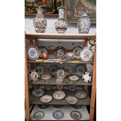 de nombreuses assiettes et vases posés sur une étagère dans une pièce