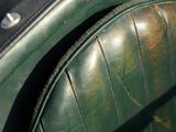 a close up of a green leather seat on a motorcycle