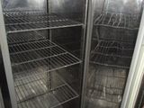 a dog that is standing in front of an open refrigerator