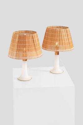 two lamps on a white pedestal with a white base and a brown shade