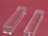 two clear plastic tubes on a red surface with a red background