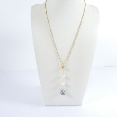 a white mannequin with a gold chain and a blue stone pendant
