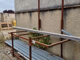 a metal bench that is sitting on the side of a building