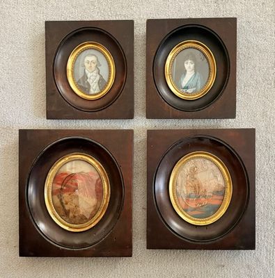 quatre portraits encadrés représentant des personnes, dans un cadre en bois accrochés au mur