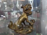 une statue représentant un chien assis sur une table en verre