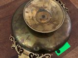 a brass plate on a wooden table with a green tag on it