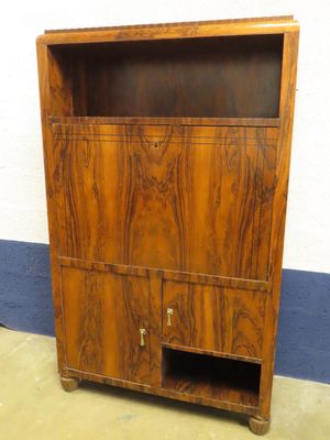 une armoire en bois dont la porte est ouverte et repose sur le sol