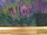 an oil painting of purple flowers in a gold frame on a table