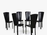 six chaises en cuir noir alignées sur un fond blanc