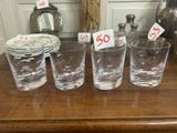 cinq verres posés sur une table, avec des étiquettes de prix dessus