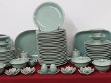 many plates and bowls on a table with a red table cloth