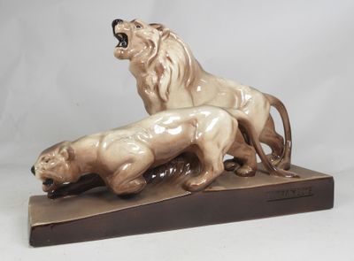 a statue of a lion and a lioness on a wooden base