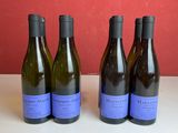 quatre bouteilles de vin sont alignées sur une table