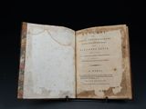 an old book opened to reveal a page of text on a black background