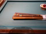 a pool table with a pool cues and a basket of balls on it