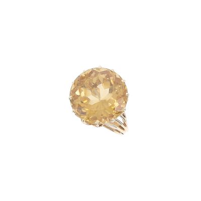 un gros plan d'une bague sertie d'un diamant jaune sur fond blanc