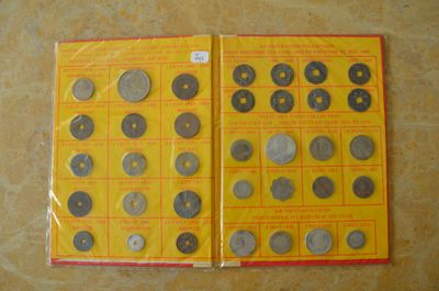 une photo d'un livre sur lequel sont posées de nombreuses pièces de monnaie