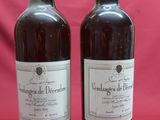 two bottles of wine sitting next to each other on a red background