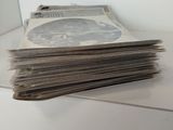 a stack of newspapers sitting on top of a white table