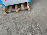 a blue machine that is sitting on a pallet