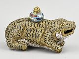 une petite figurine représentant un léopard coiffé d'un chapeau