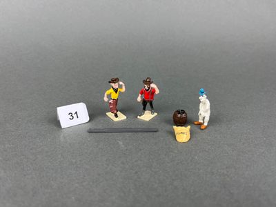 trois figurines représentant des personnes debout les unes à côté des autres