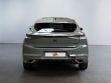 the rear end of a silver car in a room with white walls