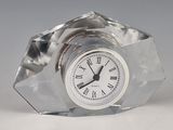 a glass clock with roman numerals on the face