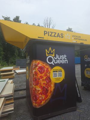 deux cartons sur lesquels sont représentées des pizzas, dans le parking