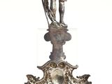 a silver vase with a statue on top of it