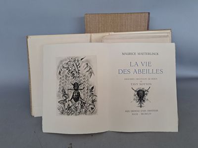 un livre ouvert posé sur une table, à côté d'une boîte en bois