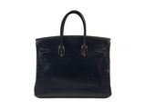 a black leather handbag on a white background