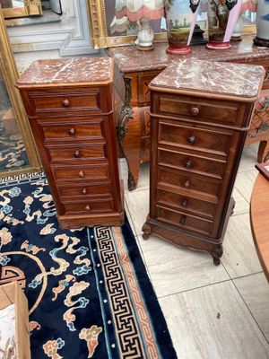 two wooden tables with marble tops in a room