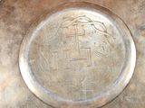 a silver plate with a picture of a bird on it