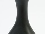 a black vase that is sitting on a white surface